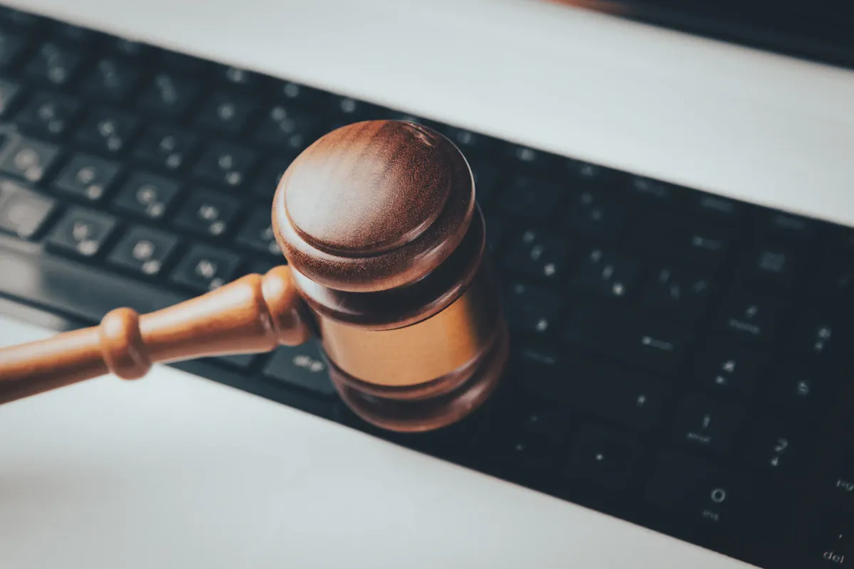 A wooden gavel resting on a computer keyboard, representing the legal consequences of an inaccessible website.